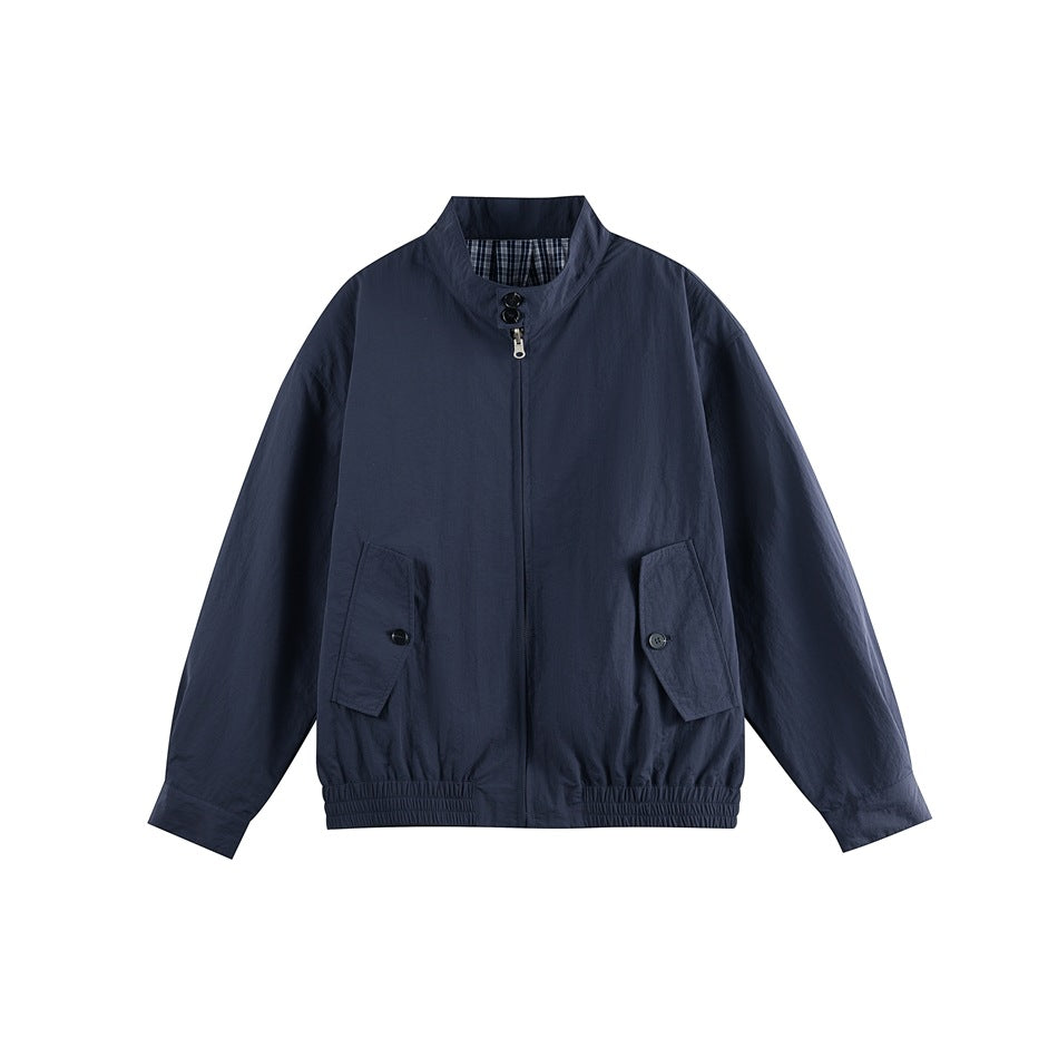 Navy zip-up stand-collar jacket with button-flap pockets and elastic hem, flat lay front view