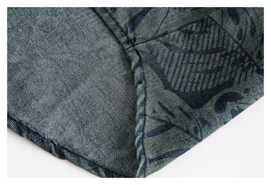 Close-up of a garment seam showing the reverse side beside blue-gray fabric with a dark abstract print.