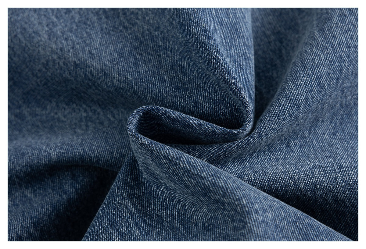 Close-up showing the textured, faded blue denim fabric of the jacket.