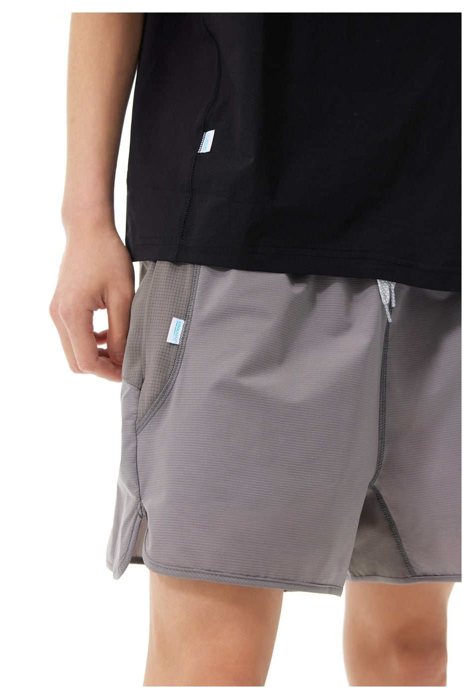 Close-up of gray shorts showing the side pocket, seam details, and drawstring waist.