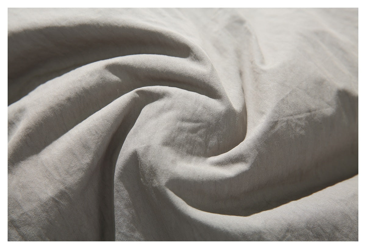 Close-up showing the softly creased surface and fine texture of taupe jacket fabric.