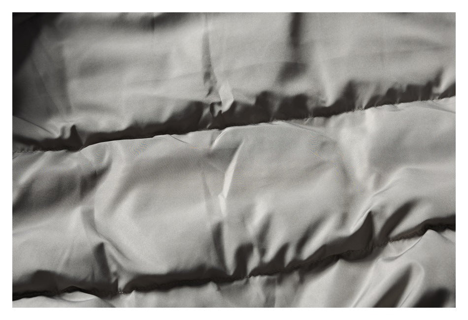Close-up of taupe garment fabric with horizontal stitched sections.