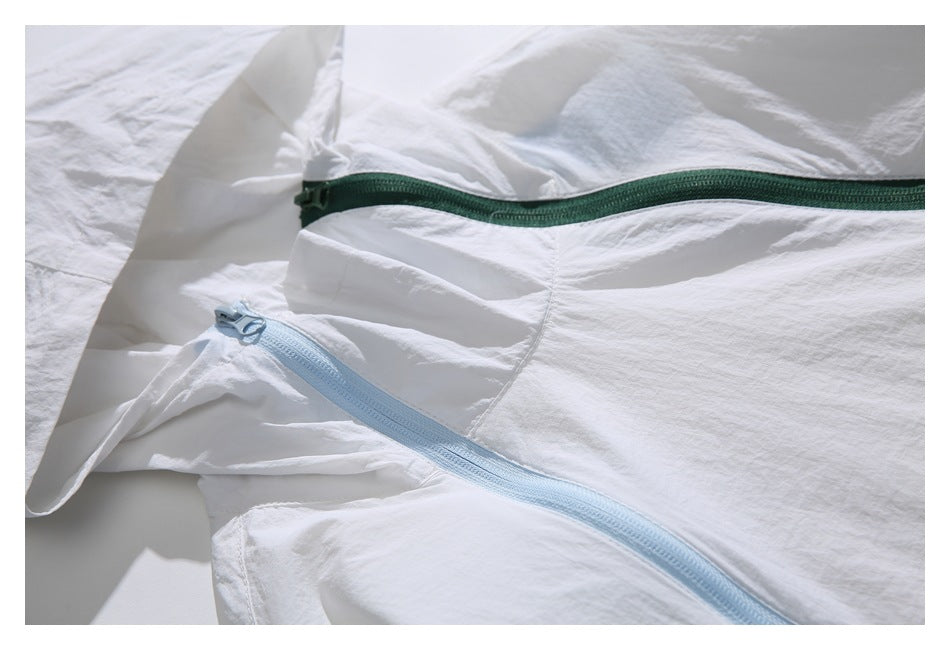 Close-up of the white jacket showing a long dark green zipper and a pale blue zipper.
