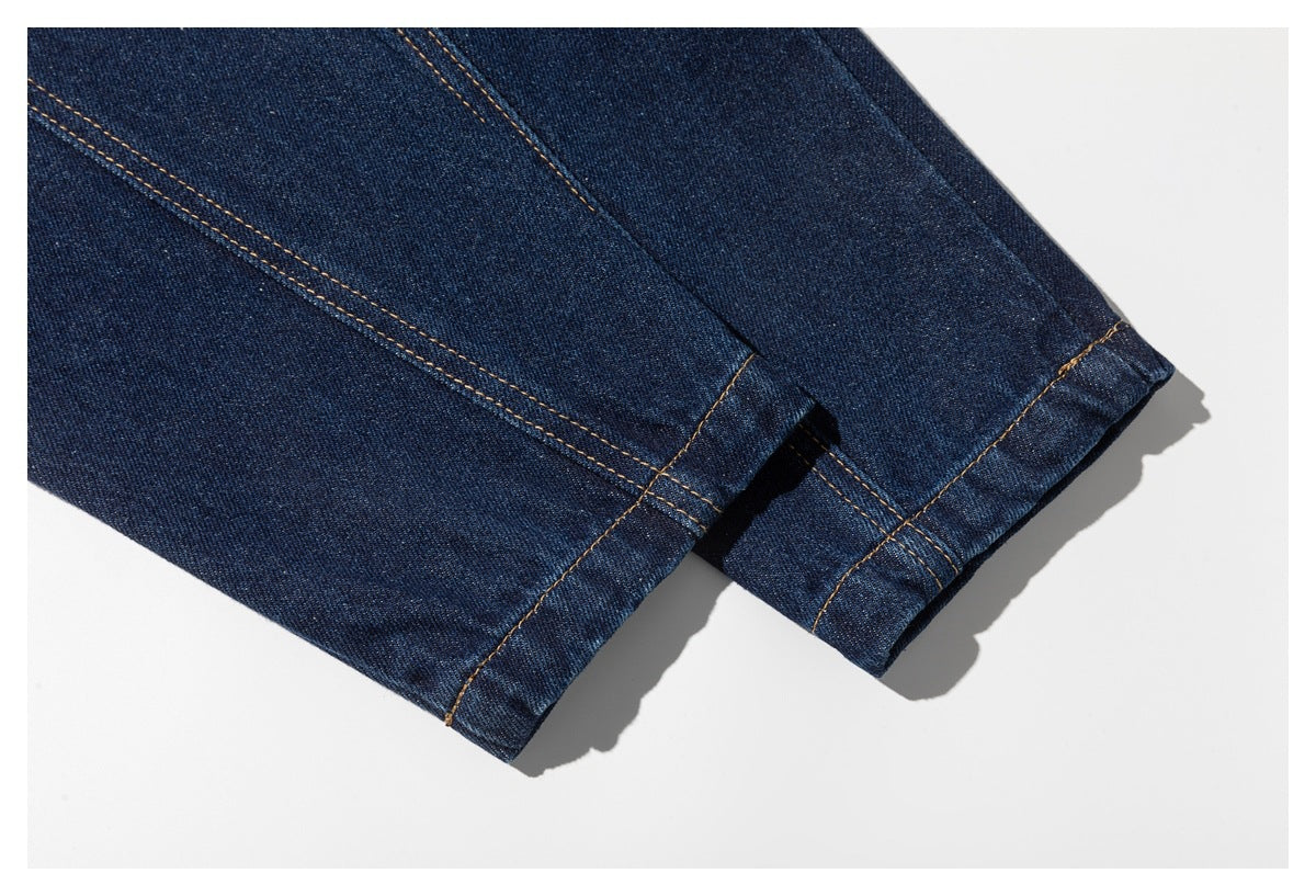 Close-up of dark indigo denim hems and seam construction with tan stitching.