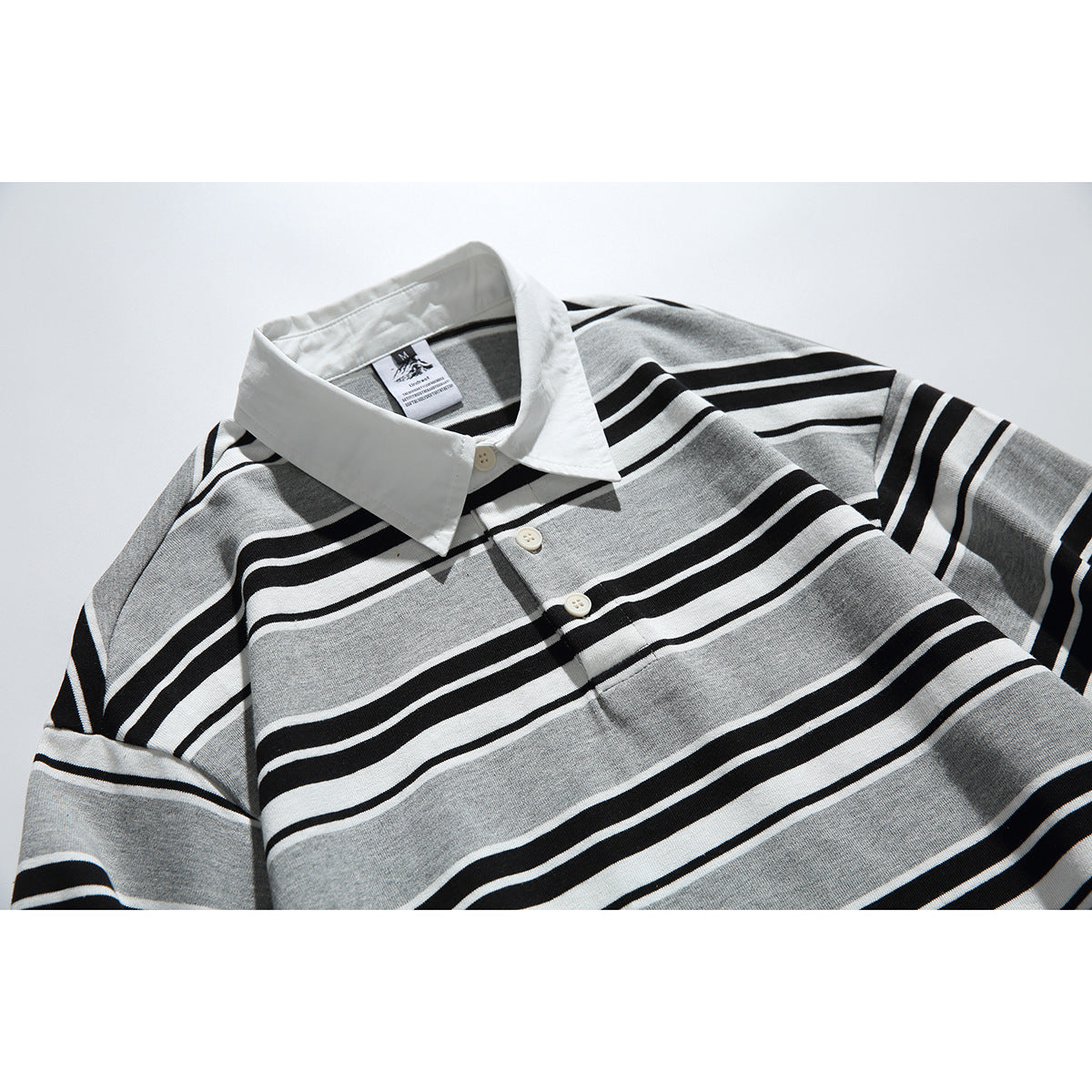 Close-up of a gray long-sleeve striped polo shirt with a white collar and button placket.