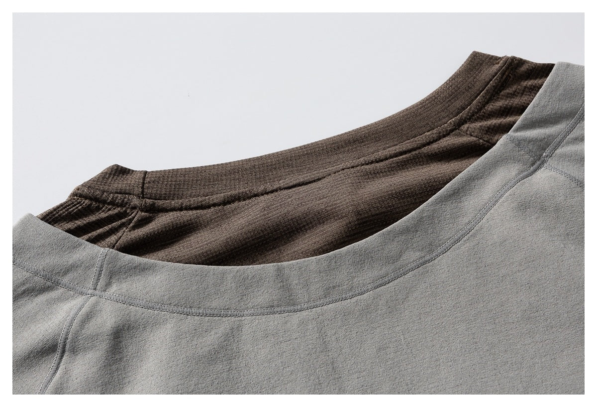 Close-up of gray and brown garment necklines, showing the curved collars and stitching.