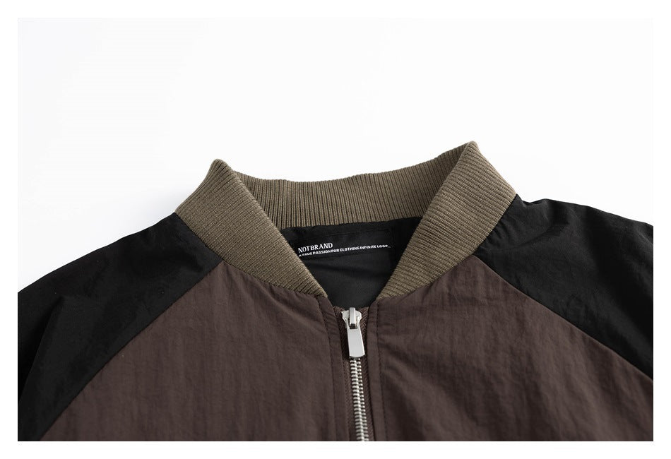 Cropped close-up of a dark brown and black jacket collar with olive ribbing, zipper and inner label.