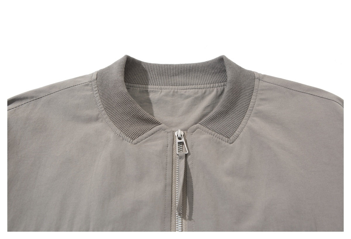 Close-up of a taupe-gray jacket's ribbed collar and silver center zipper.