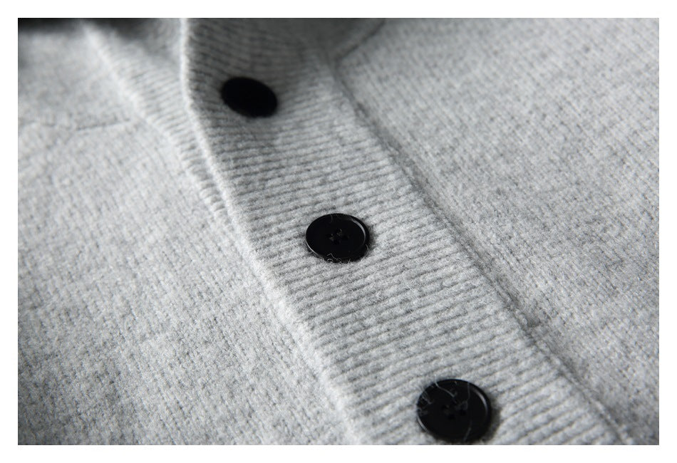 Close-up of black buttons on the gray top's ribbed front placket.