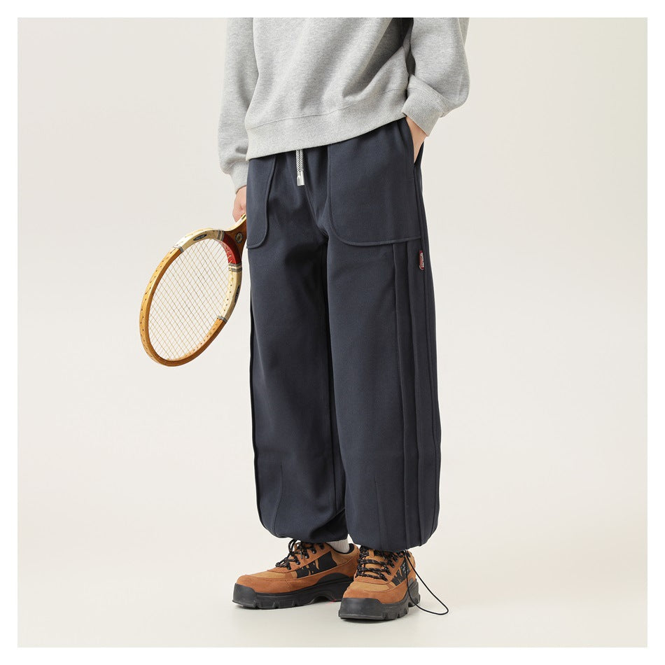Angled front view of a model in dark navy drawstring pants with large pockets; image has a white border.