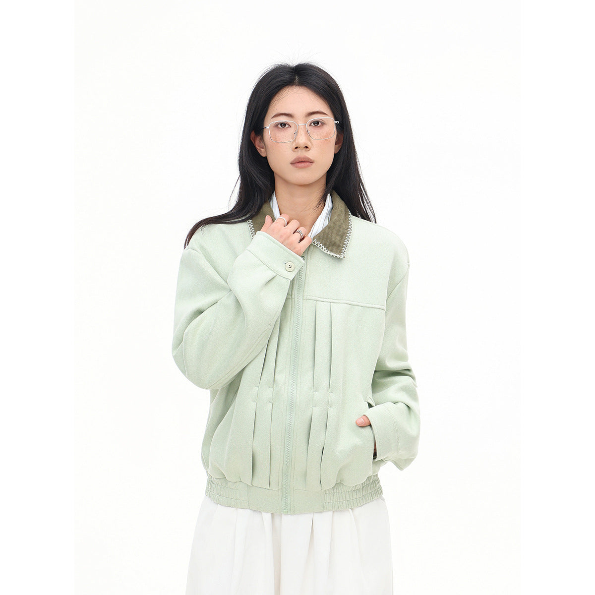 Front view of a model in a pale mint zip jacket with a contrasting stitched collar, roomy sleeves and gathered hem.