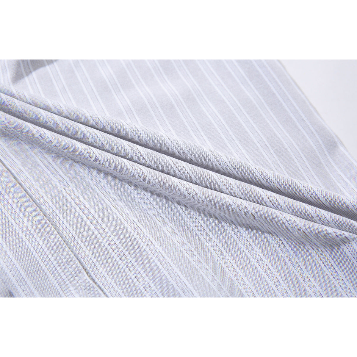 Close-up of pale gray fabric with fine white stripes, draped to show its texture.
