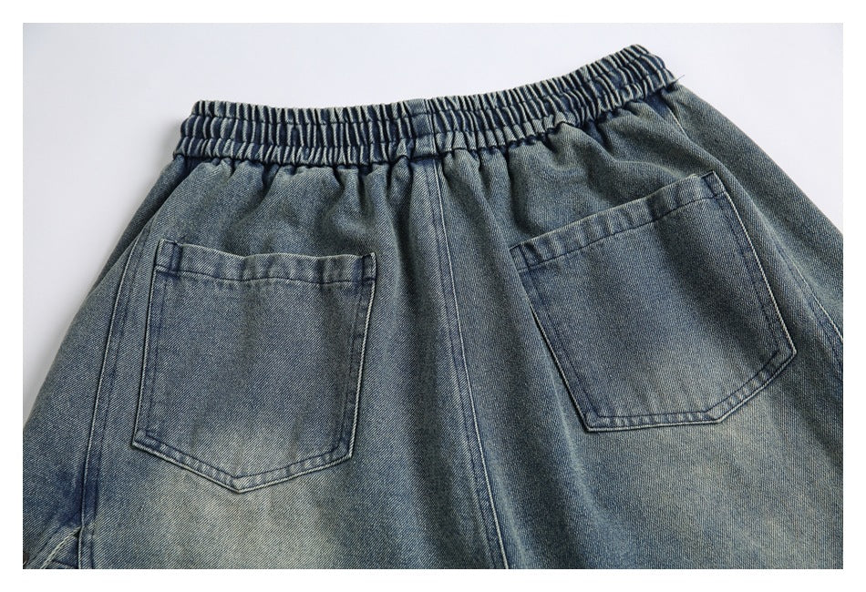 Close-up of the back of blue-gray washed denim shorts, showing an elastic waistband and two patch pockets.