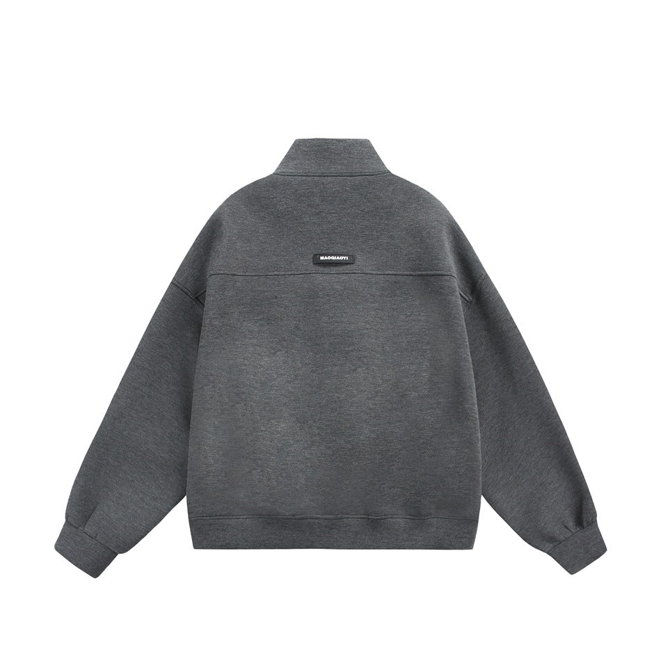 Back view of a dark gray zip-up jacket with a stand collar, dropped shoulders, and a small upper-back label.