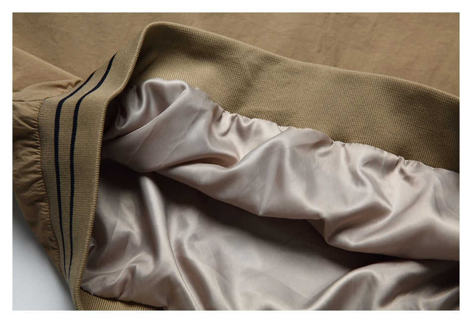 The tan jacket is opened to show its smooth light lining and striped ribbed edge.
