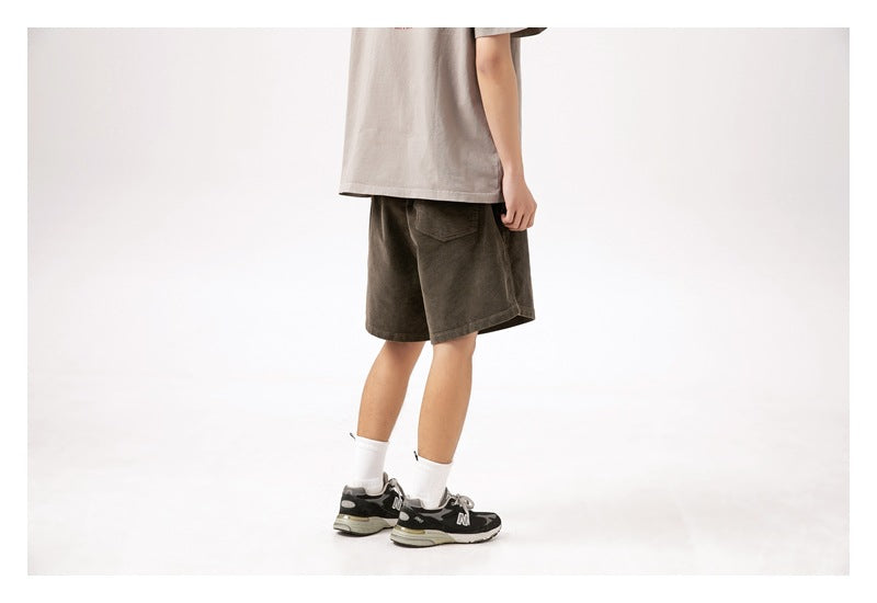 Cropped model wearing dark olive knee-length shorts, shown from the back with a single rear pocket.
