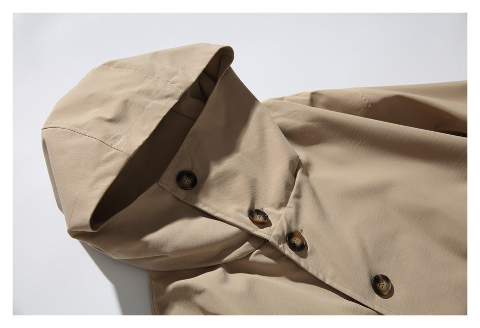Close-up of a tan coat's hood and high collar with several dark front buttons.