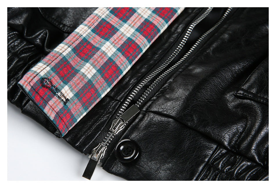 Close-up of a plaid jacket cuff, silver zipper, and black button on black material.