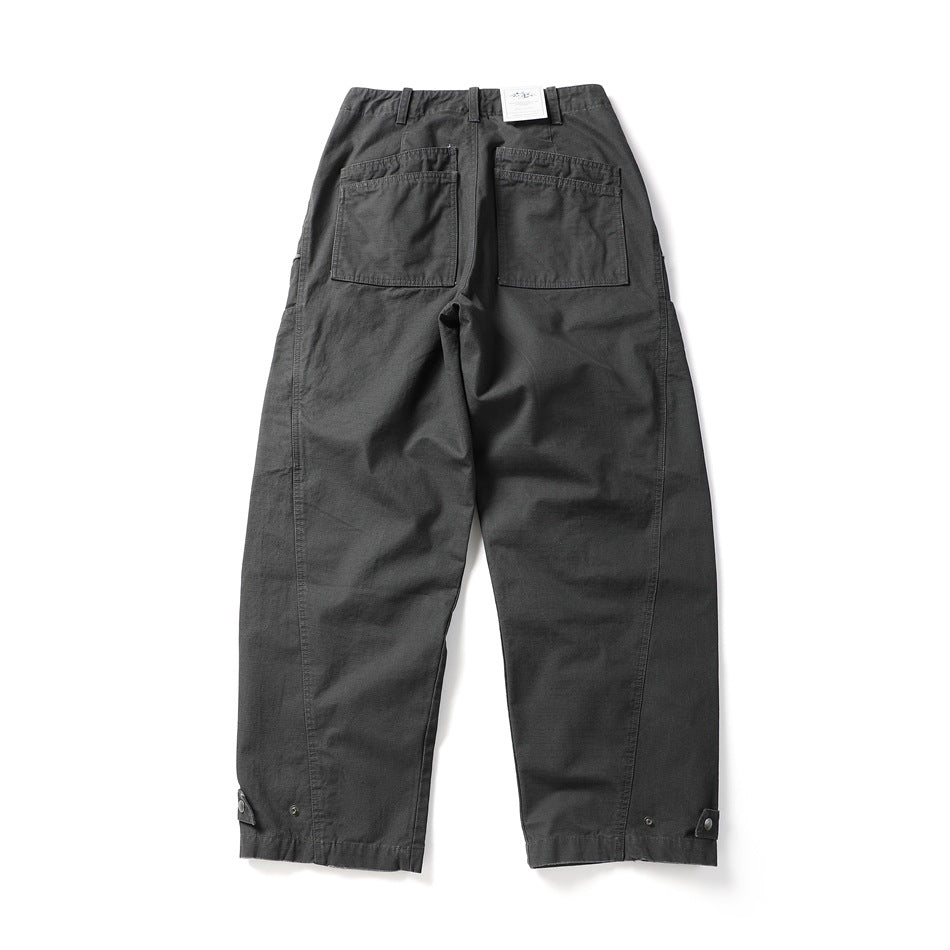 Back view of charcoal utility pants with two patch pockets and adjustable snap tabs at the hems.