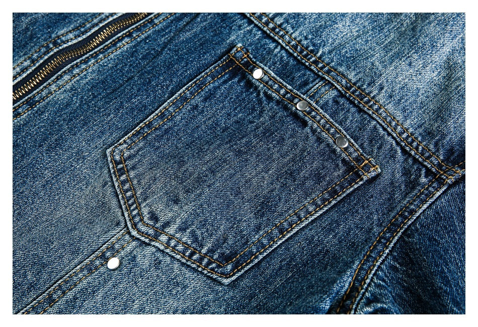 Close-up of a blue denim jacket pocket with metal rivets and contrast stitching.