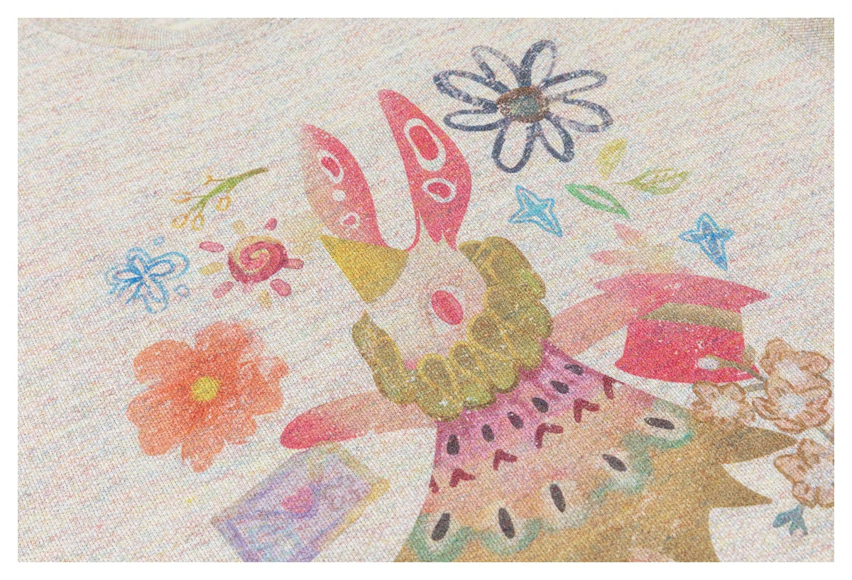 Close-up of colorful floral and whimsical cartoon prints on pale speckled fabric.