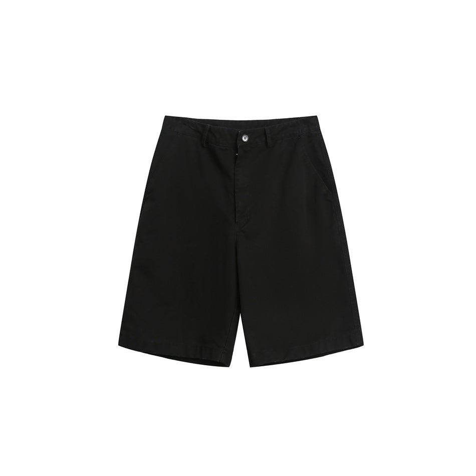 Black knee-length shorts with flat front, button fly, belt loops and side pockets, flat lay on white