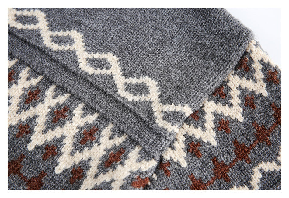Close-up of gray knit with cream and rust geometric motifs and a diagonal seam.