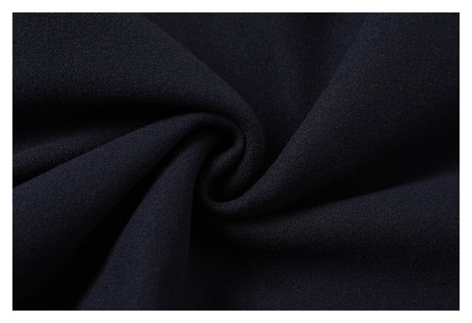 Close-up of dark navy fabric twisted into a spiral fold, showing its fine textured surface.