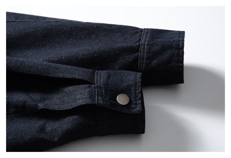 Close-up of dark indigo jacket sleeves, showing a snap-tab cuff and a plain cuff.
