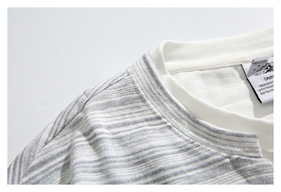 Close-up of the cream crew neckline and gray-and-white striped shoulder, with a small inside neck label.