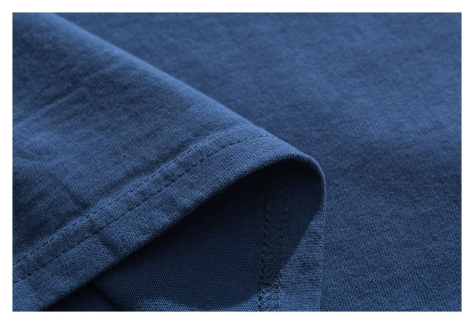 Close-up of a blue garment hem with visible stitching and an overlocked seam.