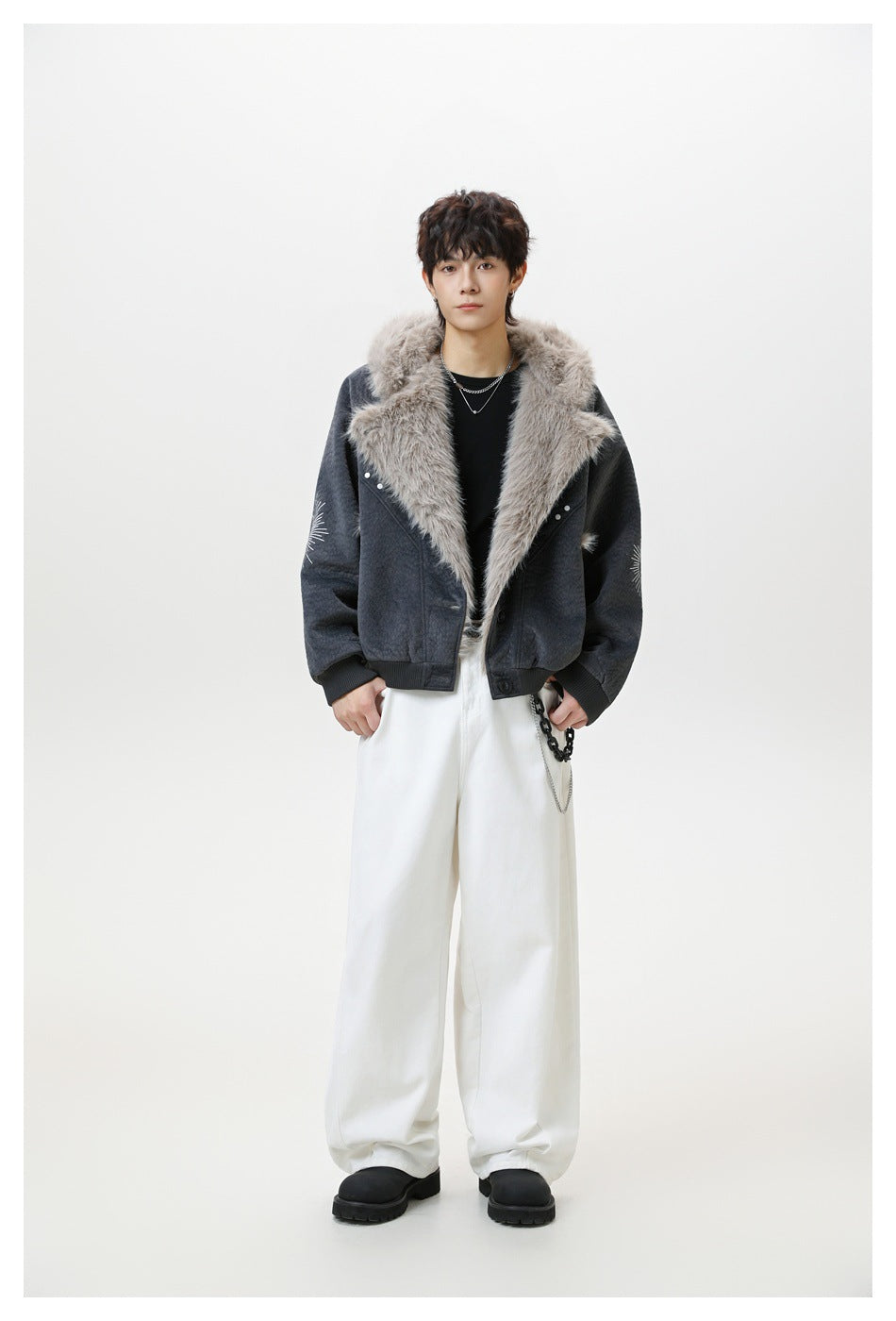 Model wearing a charcoal jacket with a light fur collar and sunburst designs on the sleeves.