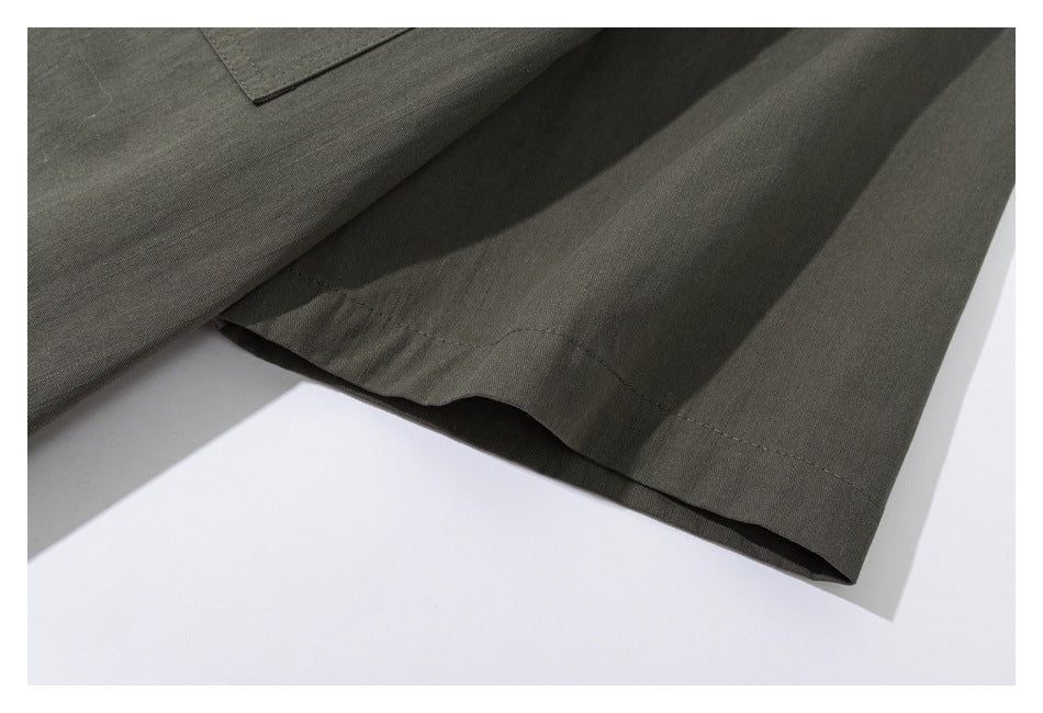 Close-up of a stitched hem on a dark olive garment.
