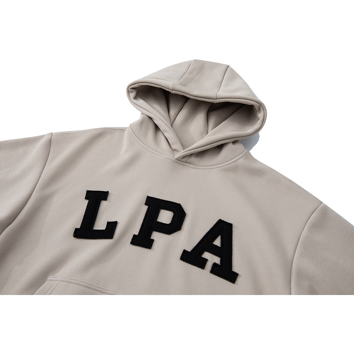 Close-up of a light beige pullover hoodie with a hood and large black LPA lettering on the chest.