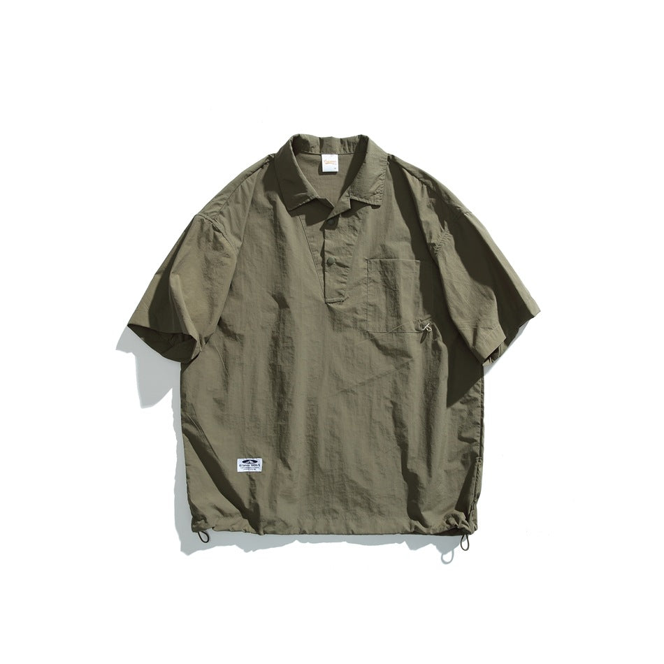 Olive green short-sleeve pullover shirt with collar, snap placket, chest pocket and drawcord hem, flat lay