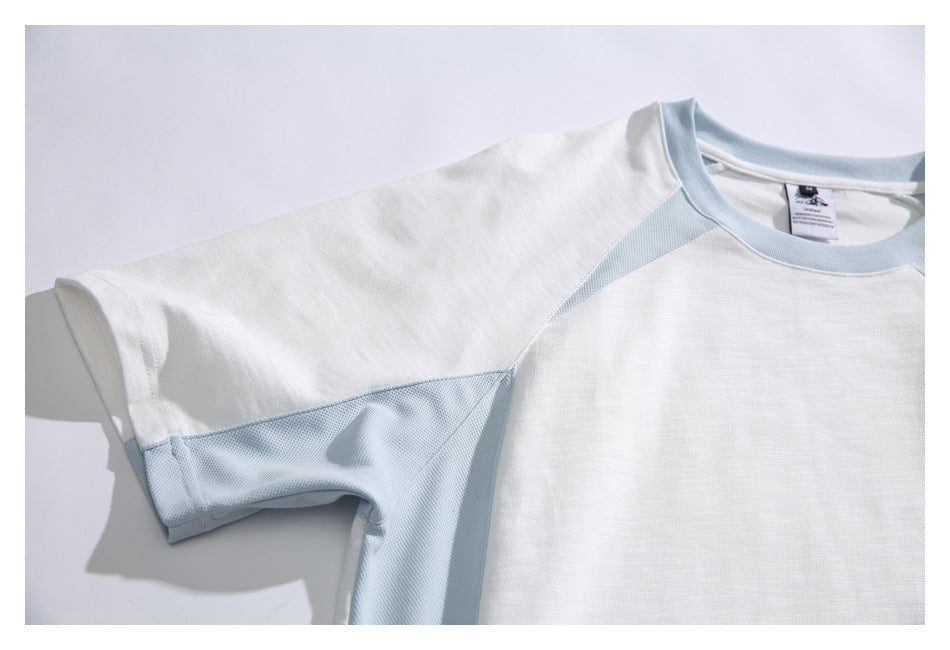 Partial flat-lay front view of a white short-sleeve T-shirt with pale blue mesh side panels and neckline.