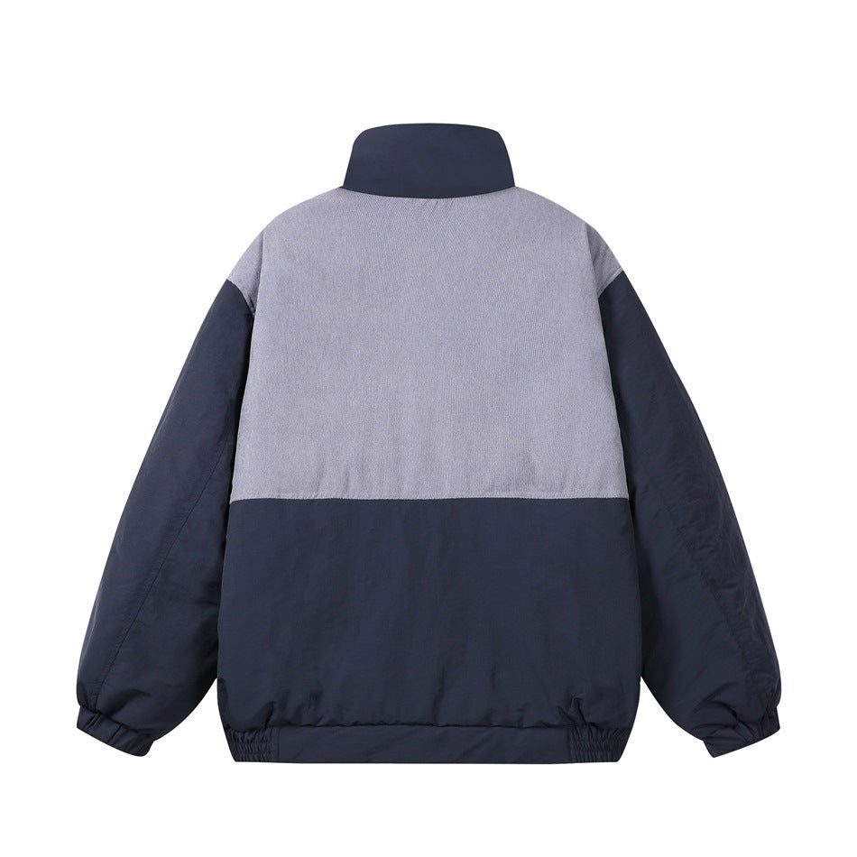 Back view of navy padded stand-collar jacket with gray-lavender textured upper back panel and elasticated cuffs and hem