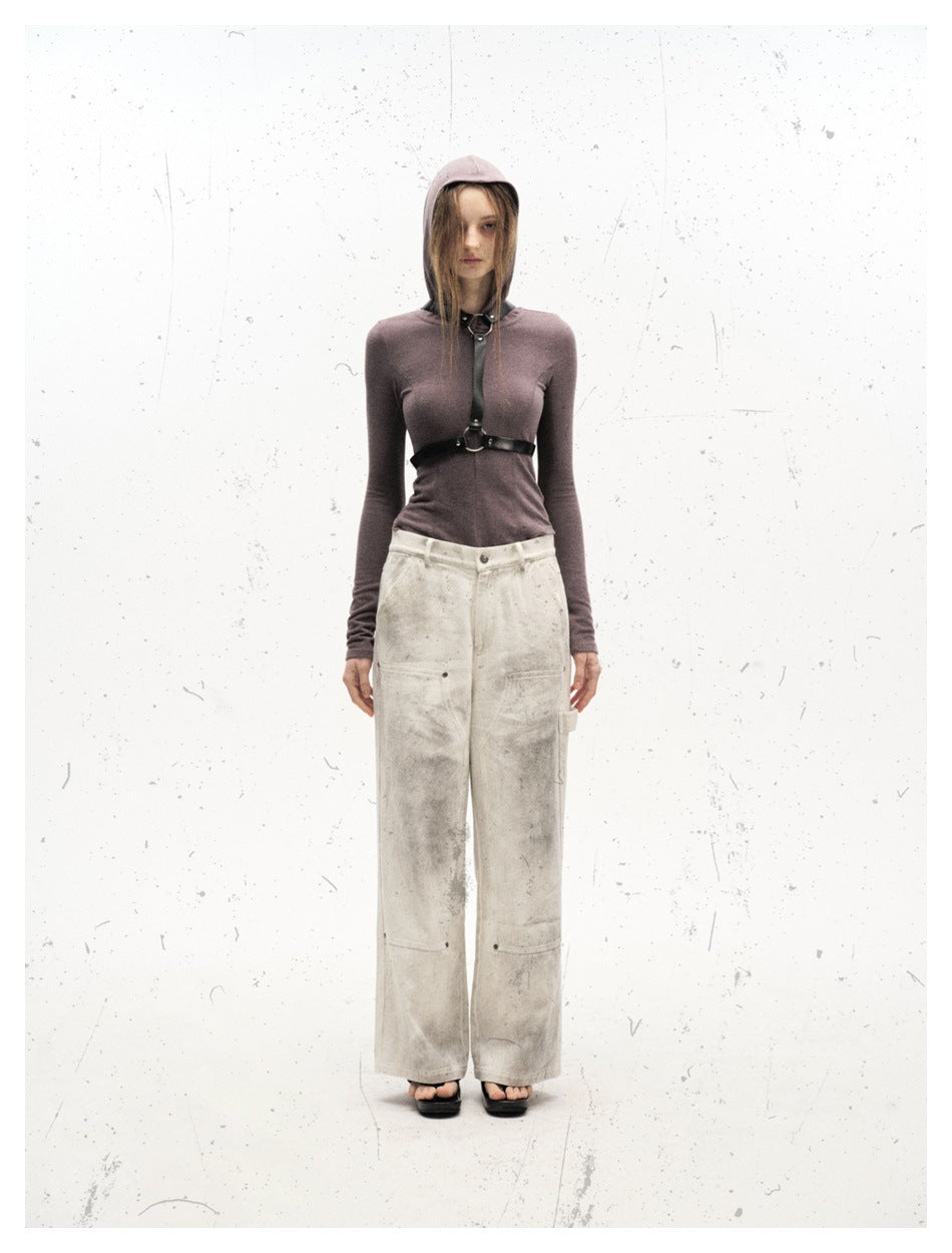 Model wearing off-white distressed wide-leg carpenter pants with a mauve hooded top and black harness