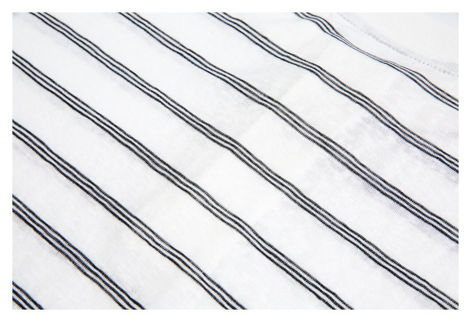 Close-up of white fabric with narrow black parallel stripes running diagonally.