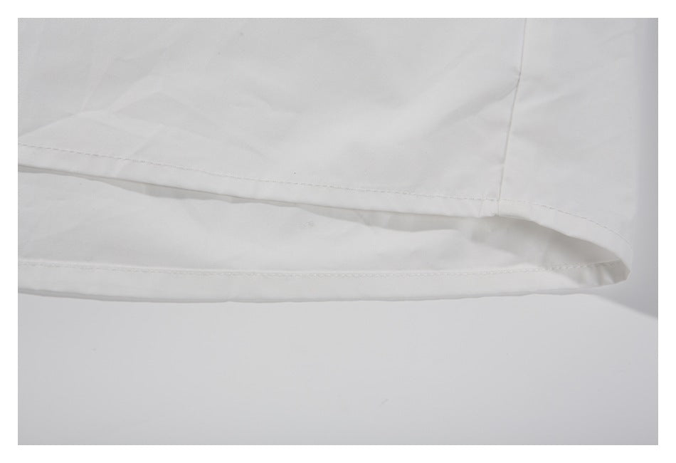 Close-up of the white garment's stitched lower hem.
