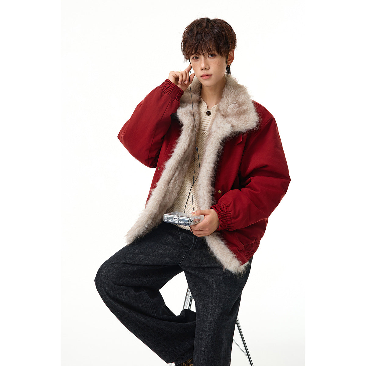 Model wearing a red jacket with a wide pale faux-fur collar and lining, styled with dark jeans.