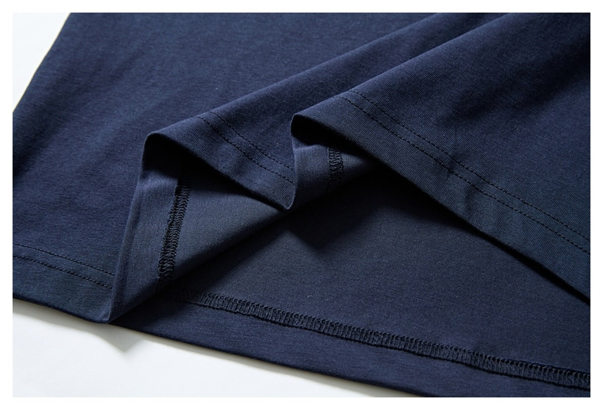 Close-up of the navy garment's folded hem, showing the inside overlock stitching and outer seam.