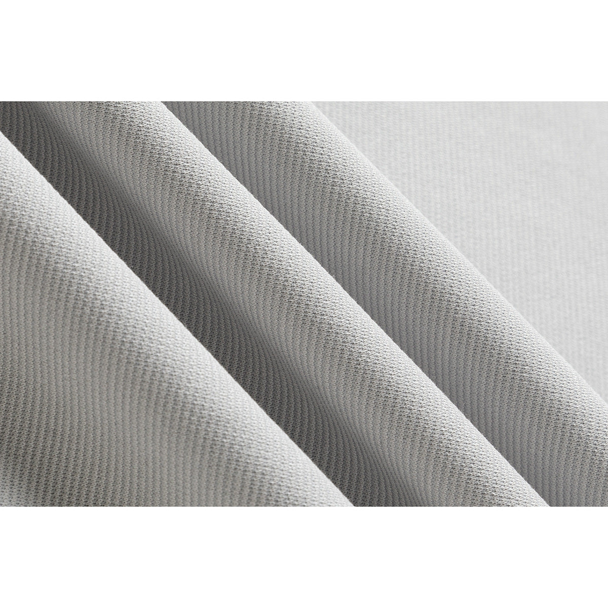 Macro view of the light gray polo shirt's textured fabric, draped in folds.