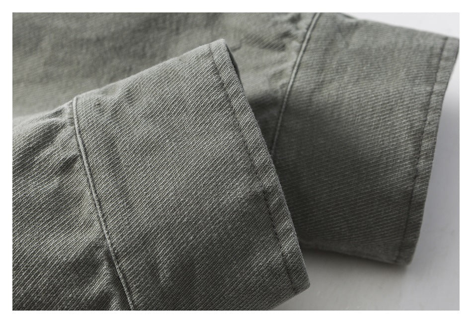 Close-up of a gray garment cuff showing its ribbed knit texture and stitched seam.