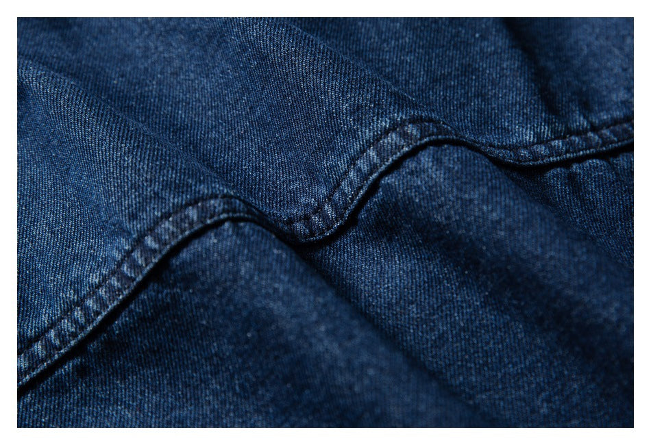 Close-up of dark indigo denim fabric with a curved stitched seam.