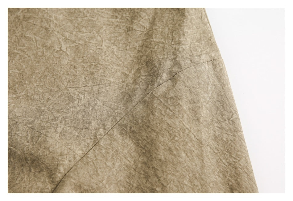 Close-up of taupe-brown mottled fabric with a curved stitched seam.
