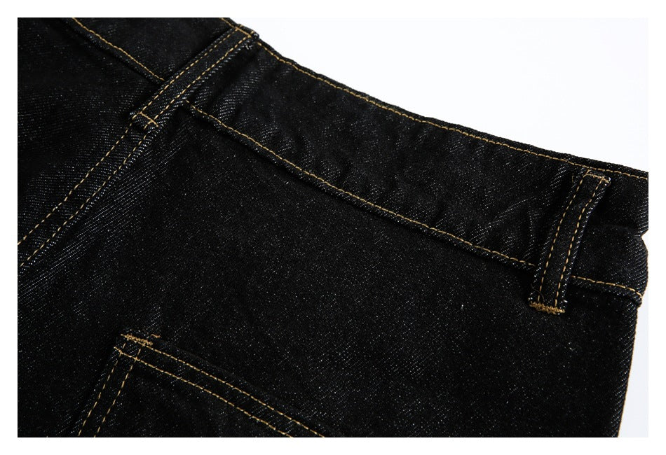 Close-up of black jeans showing the waistband, belt loops and part of a rear pocket.