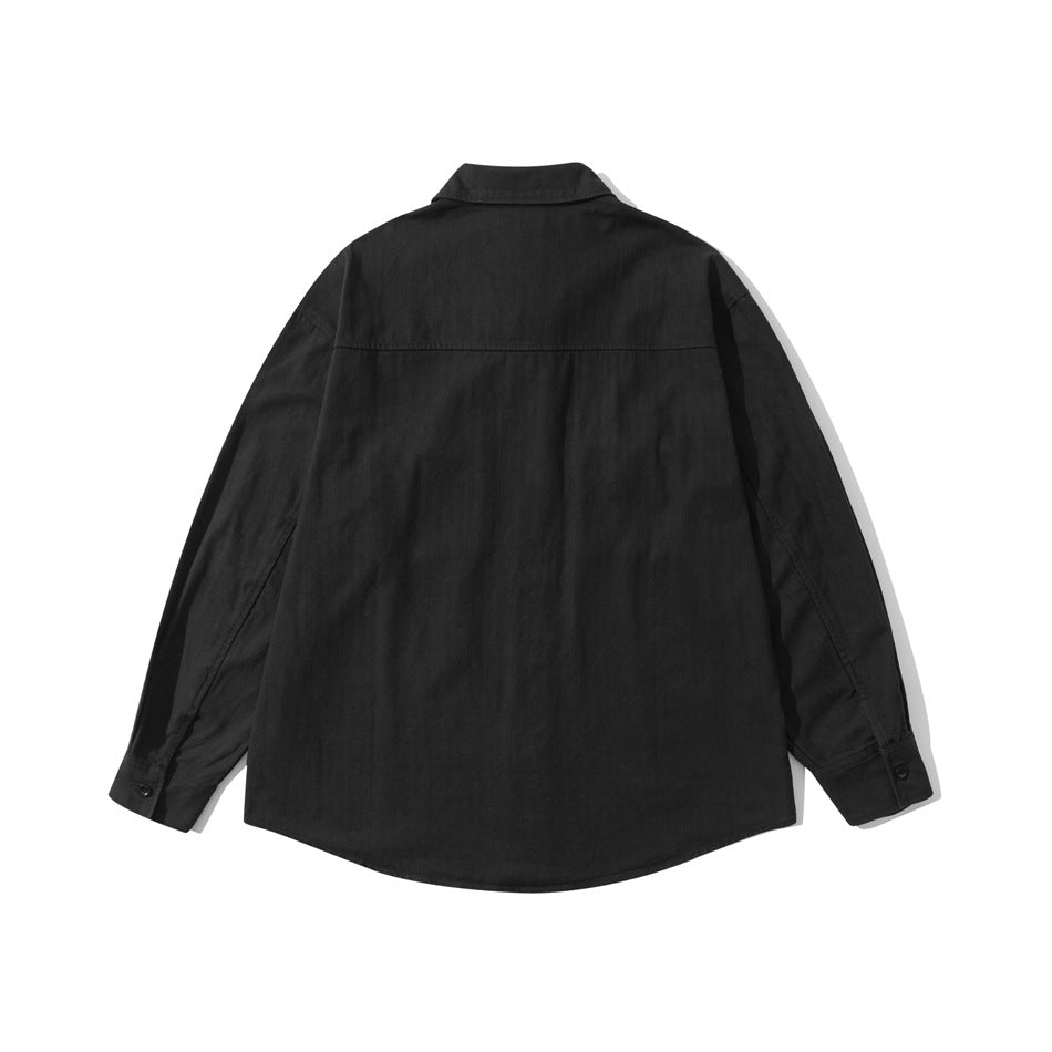 Back view of black long-sleeve shirt showing back yoke seam, curved hem and buttoned cuffs, flat lay
