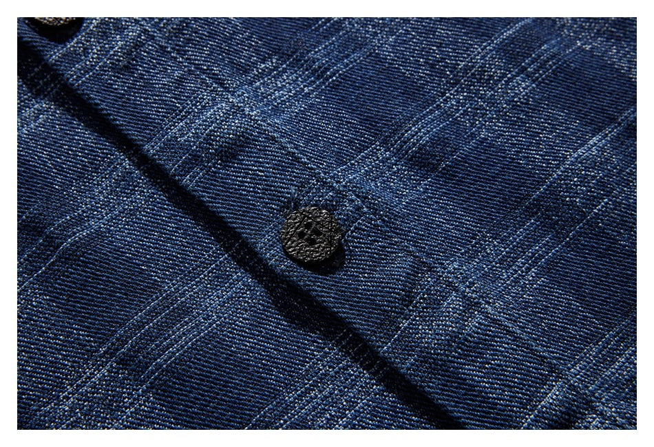 Close-up of a dark button on the blue plaid shirt fabric.