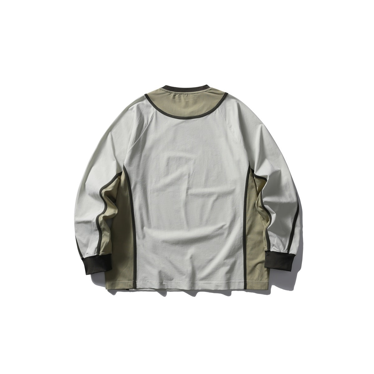 Back of an off-white long-sleeve shirt with khaki shoulder and side panels, dark piping, and dark cuffs.